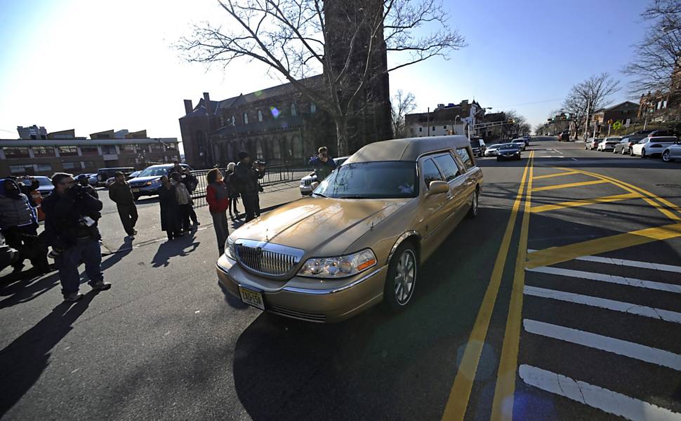 Carro funerário com corpo de Whitney Houston chega à igreja batista onde é realizado velório da cantora