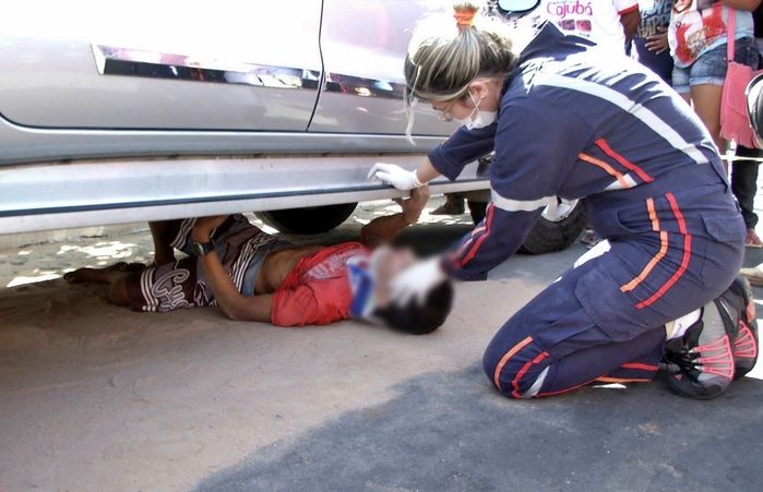 Vítima sendo retirada de debaixo do carro. (Foto: João Júnior)