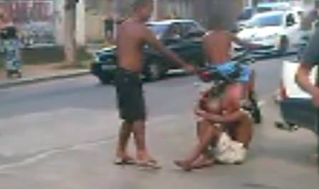 Momento em que homem executa a vítima, sentada no chão