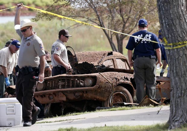 Agentes de diferentes órgãos policiais investigam os carros encontrados no lago Foss, em Oklahoma (Foto: Sue Ogrocki/AP)