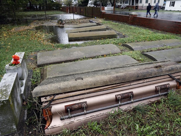 30 de outubro - Caixão saiu parcialmente de sua cova no cemitério de Crisfield, em Maryland, devido à força da supertempestade Sandy. Centenas de pessoas ficaram desabrigadas na cidade devido às enchentes (Foto: Alex Brandon/AP)