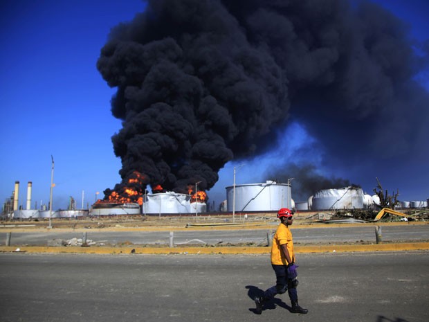 Fogo ainda era visto neste sábado na área da refinaria (Foto: AP)