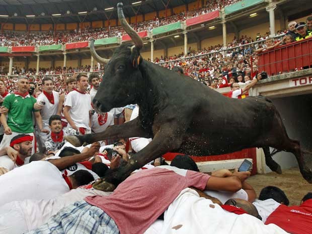 Touro salta sobre as pessoas na segunda corrida do Festival de São Firmino (Foto: Joseba Etxaburu / Reuters)