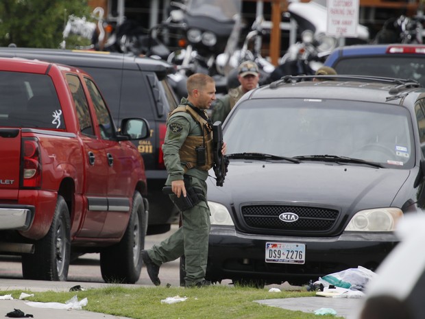 Policial caminha em cena de confronto que deixou mortos e feridos no Texas neste domingo (17) (Foto: Rod Aydelotte/Waco Tribune-Herald via AP)