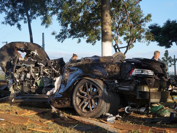 Carro de luxo ficou destruído após acidente durante a madrugada na Marginal Pinheiros, altura da Ponte do Socorro, em São Paulo. O motorista perdeu controle do veículo e bateu em uma árvore. Os dois homens a bordo sobreviveram e foram levados ao hospital (Foto: Alexandre Serpa/Futura Press/Estadão Conteúdo)