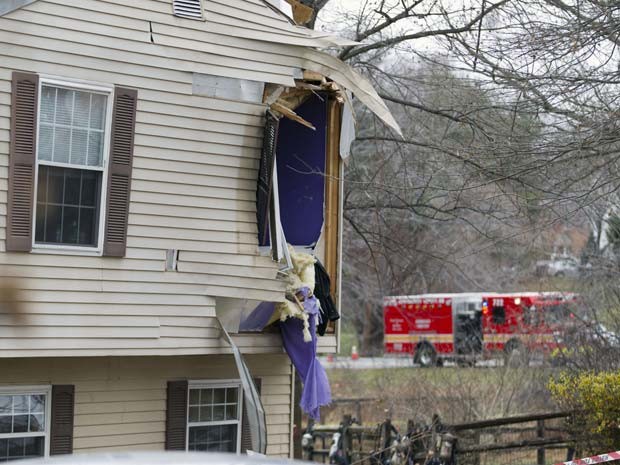 Janela de casa em Gaithersburg fica danificada após a queda de um avião nesta segunda-feira (8) (Foto: AP Photo/Jose Luis Magana)