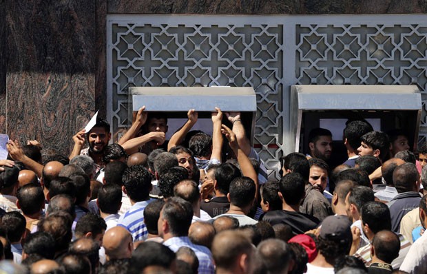 Dezenas de palestinos aguardam para sacar dinheiro em banco da cidade de Gaza nesta quinta-feira (17) (Foto: Mohammed Salem/Reuters)