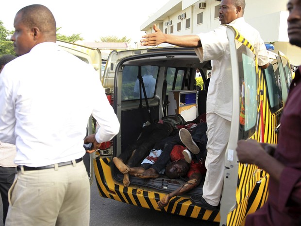 Vítimas de explosão de bomba são colocadas em caçamba de uma picape em Abuja (Foto: Afolabi Sotunde/Reuters)