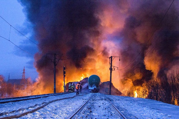  Bombeiros e equipes de emergência enfrentam incêndio em trem cargueiros nesta quarta-feira (50) próximo a Posdino, na Rússia. (Foto: AP)