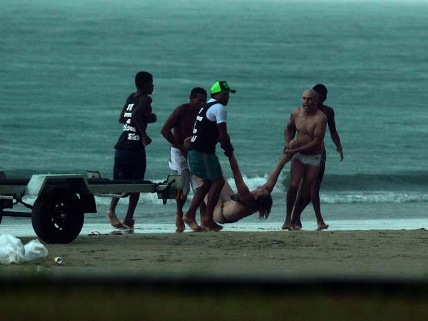 Banhistas socorrem a vítima na praia da Enseada, em Guarujá (Foto: Rogério Soares / Jornal A Tribuna)