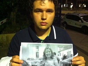 Leonardo Leite Santos mostra uma foto da mãe, Valéria Santos Leite, em frente ao IML Central de São Paulo (Foto: Gabriela Gasparin/G1)