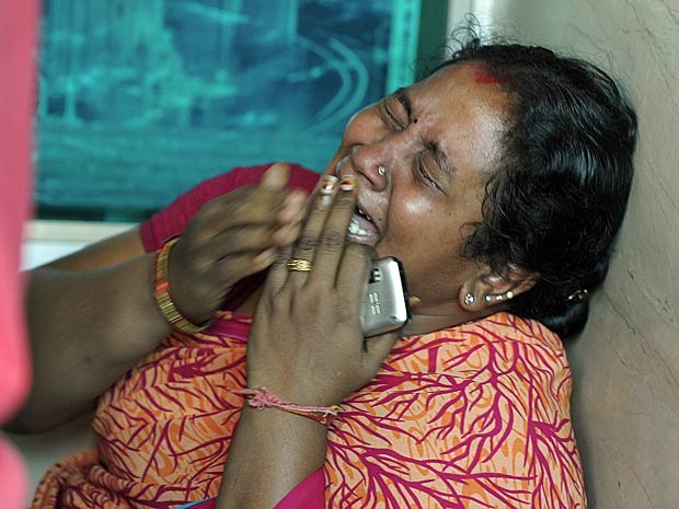 Mulher chora a morte de um parente em acidente com um ônibus na Índia. (Foto: Noah Seelam / AFP Photo)