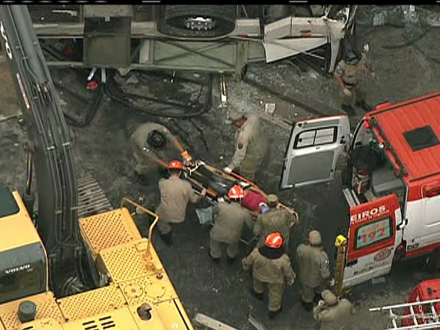 Outra vítima é levada para ambulância, após queda de ônibus (Foto: Reprodução / TV Globo)